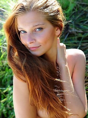 Indi flaunts her gorgeous, naked body and alluring beauty with a warm, engaging smile   outdoors.